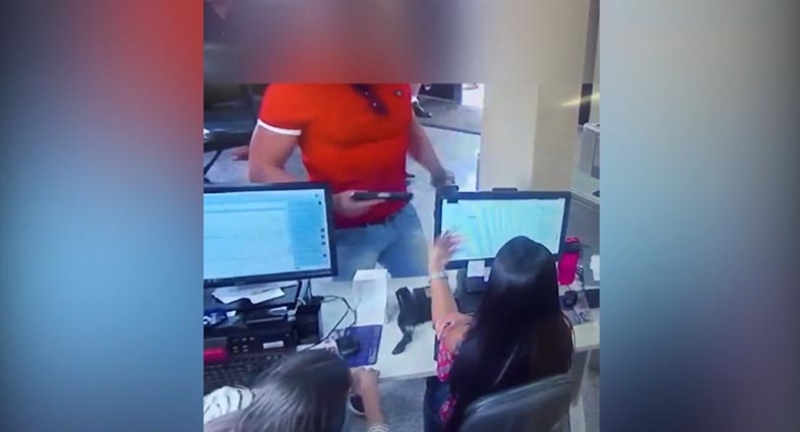 Policial civil mostra arma para recepcionista do Ipasgo em Goiânia