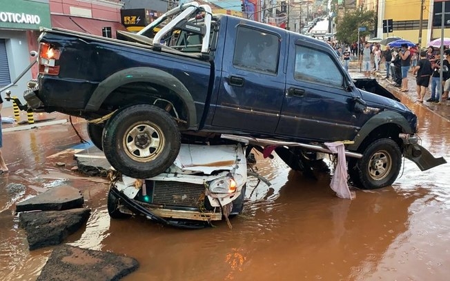 Enxurrada arrasta veículos e derruba caminhão em SP