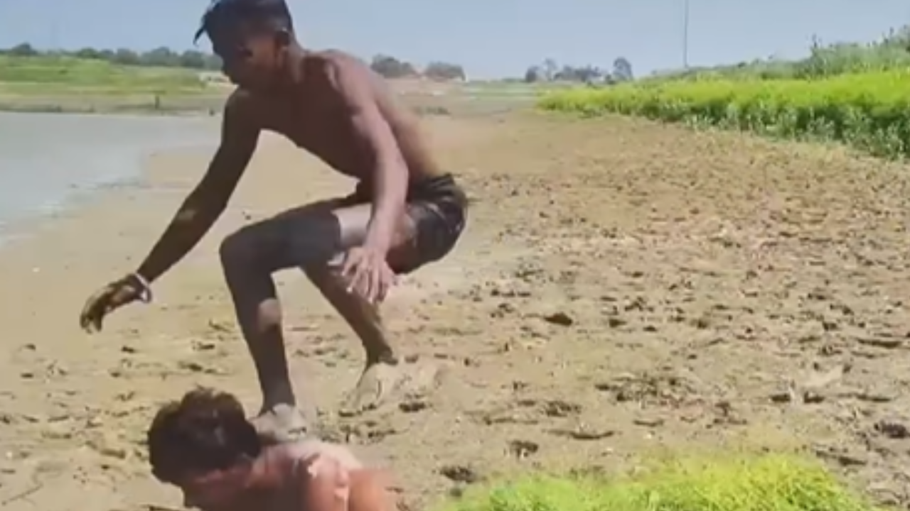 Jovem fica preso em lama após salto acrobático à beira de rio