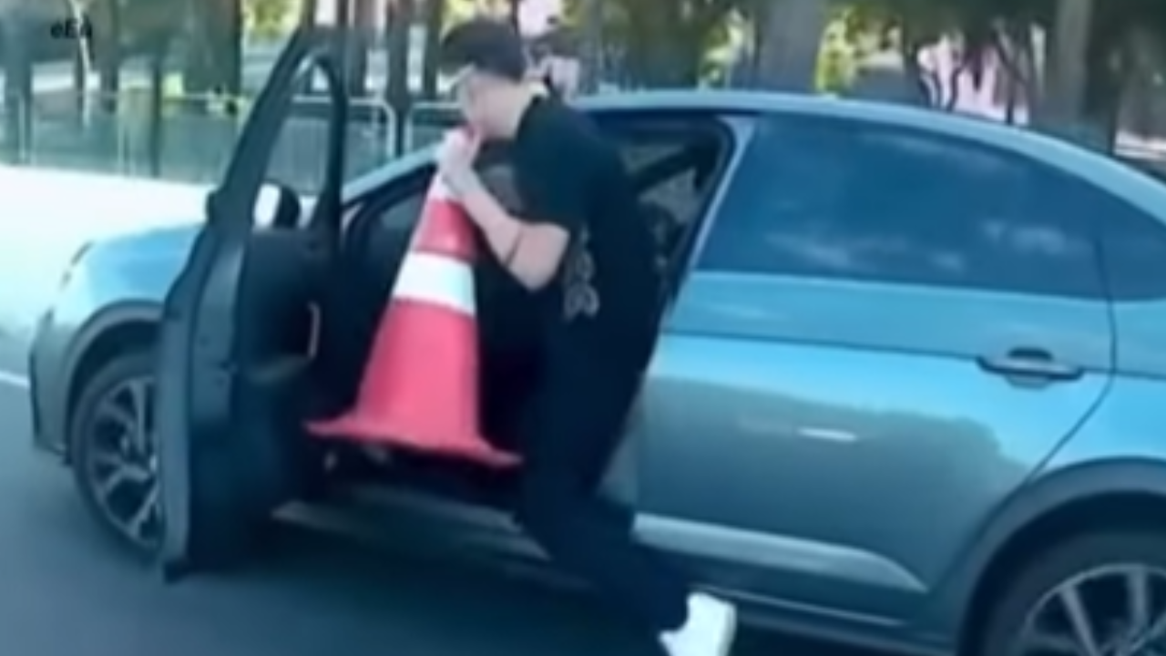 Carro em movimento: motorista sai, volta e recolhe cone na pista