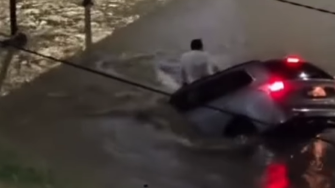 Homem é arrastado por correnteza e sobrevive após carro ser engolido por buraco