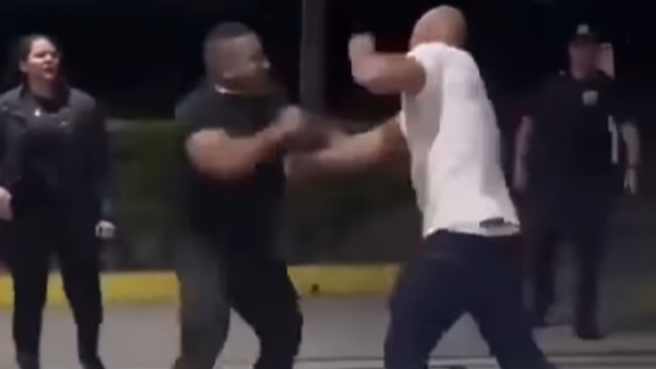 Homem com camisa de segurança agride rapaz de camisa branca durante confusão