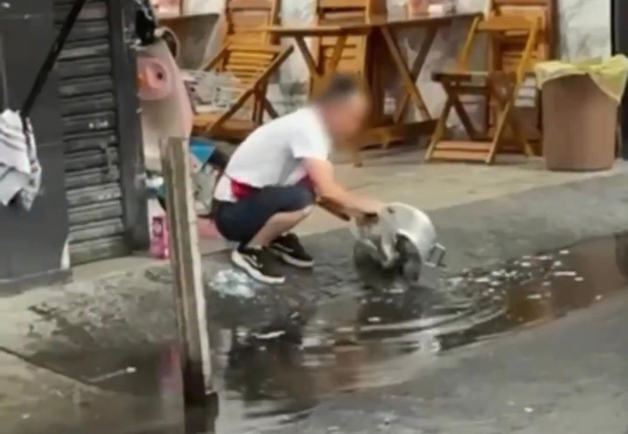 Vídeo: Homem lava panela com água de poça na rua e cena que gera polêmica