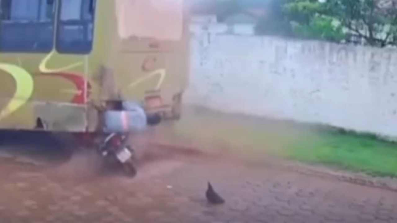 Motociclista bate em ônibus parado e fica preso; veja vídeo